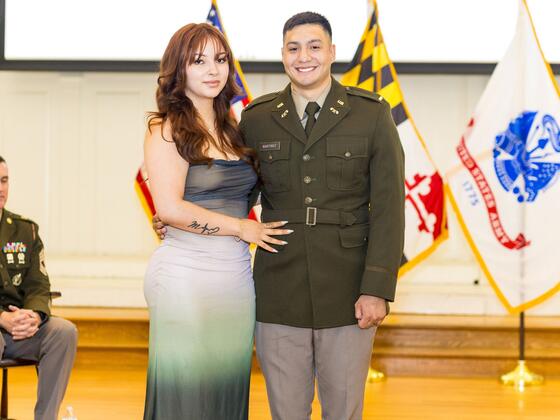 A cadet poses with his wife on stage.
