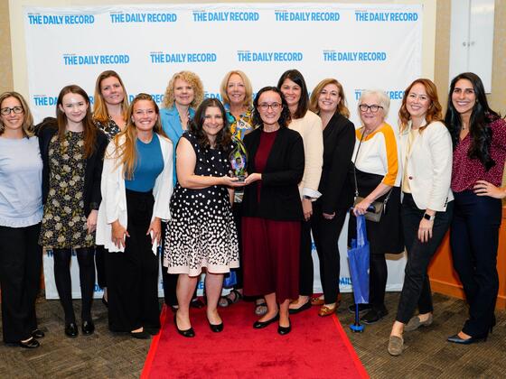 A group photo of McDaniel Women's Leadership Network members, President Jasken, and others, posing with an award at the Empowering Women Awards. 