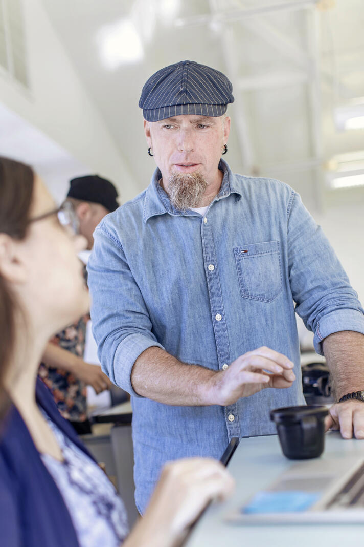 Professor Steven Pearson speaking to a student in the classroom.