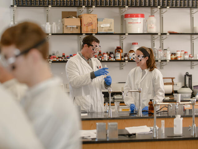 Professor with students in research lab.