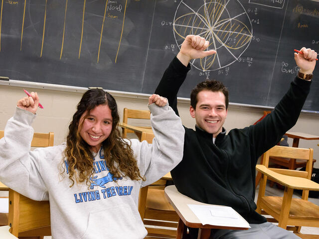 Estimathon Kathalyn Urquizo and Dimitri Lezcano raising their arms in celebration.