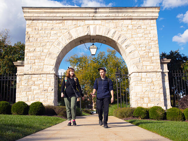 Students walking under the arch