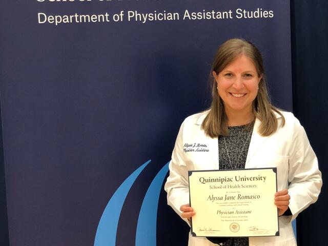 Photo of alumna Alyssa Romasco holding her degree from Quinnipiac University.