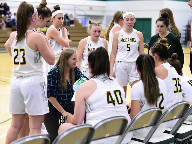 Women's Basketball in Huddle with Coach