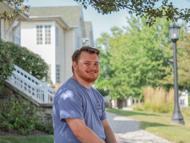 Photo of a student sitting outside.