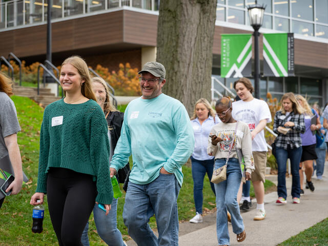 Students and parents walking down a path laughing