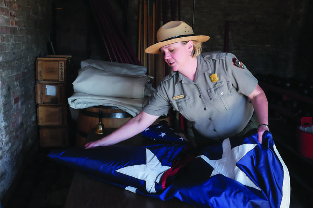 Abbi Wicklein-Bayne folding the American flag while wearing her ranger uniform.