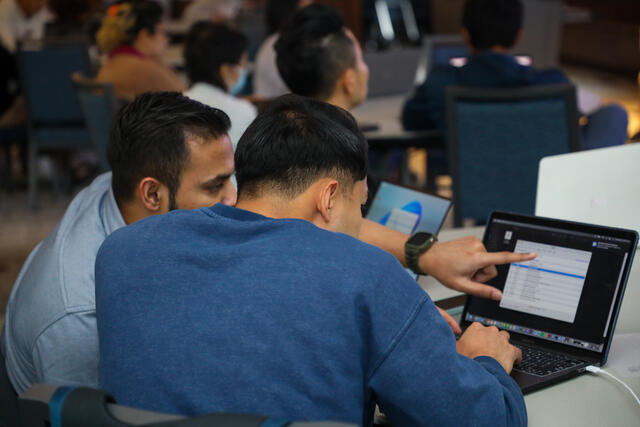 Two Data Analytics students collaborate at a computer.