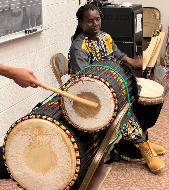 učí studenty západoafrické bubnováníučí studenty západoafrické bubnování  