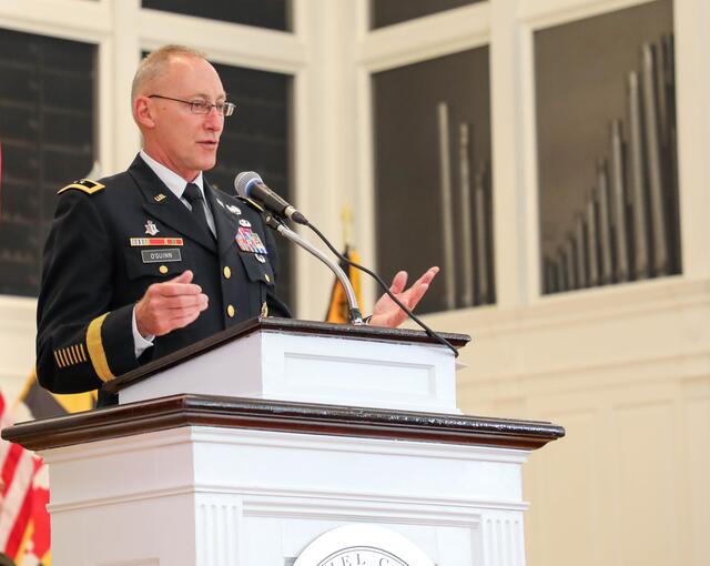 Photo of Michael O'Guinn at the podium for the 2023 Commissioning.