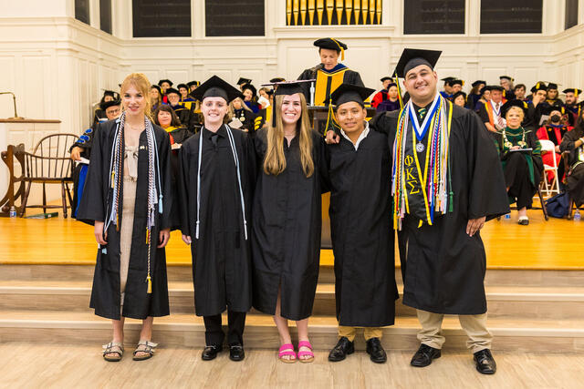 Group of students in graduation regalia pose