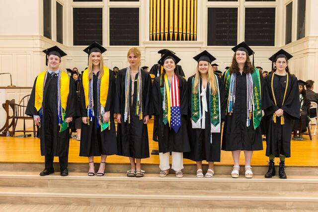 students in regalia pose