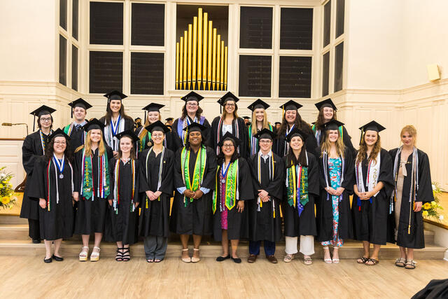 Group of students in graduation regalia pose