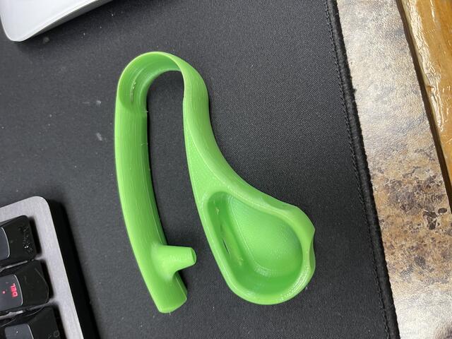 A bright green 3D printed blister pack opener.
