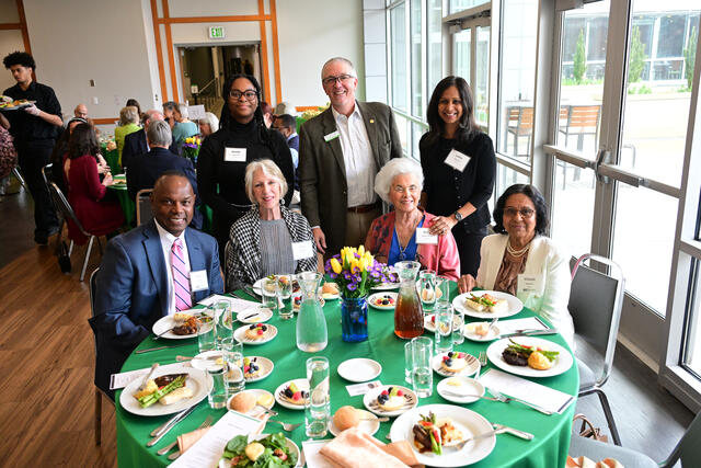 Group of people sit at a round table at a formal event