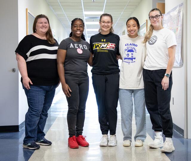 A group photo of professor Allison Kerwin and her four female student-researchers.