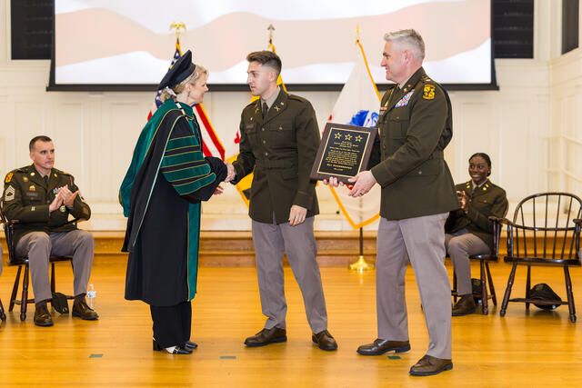 President Jasken hands an ROTC student an award during Commissioning.