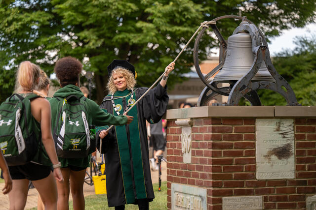 McDaniel President Julia Jasken helps students ring Old Main bell.