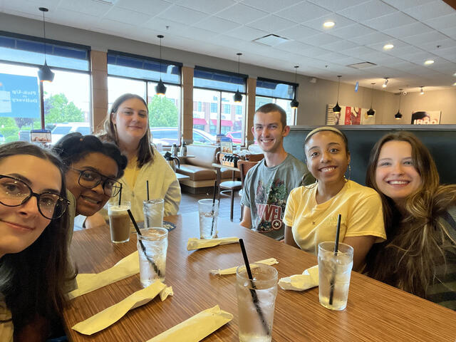 A group of students smiling at a table