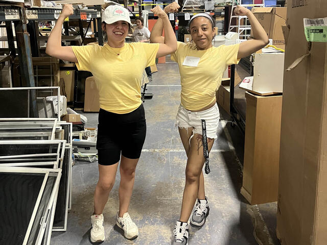 Two girls with yellow shirts flexing their arms