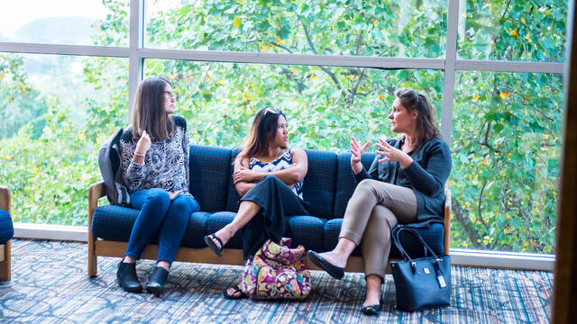 Grad students in conversation in lobby.