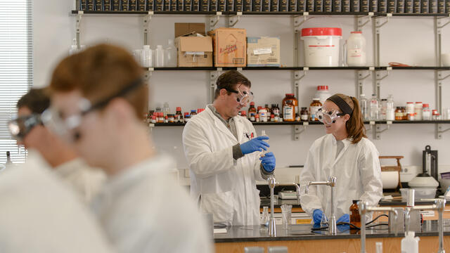 Professor with students in research lab.