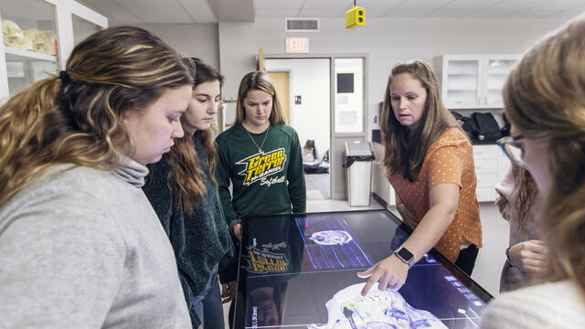 Students using a large touchscreen to view anatomy.