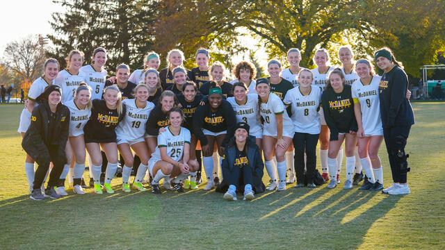 Women's soccer team photo on a grassy field.